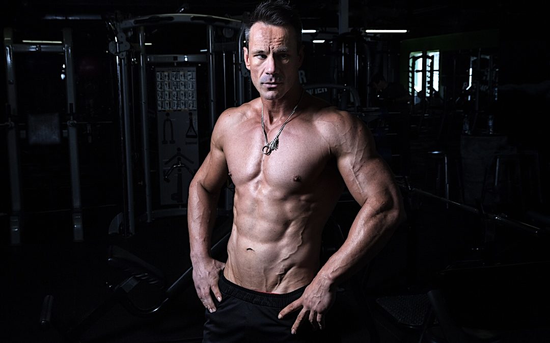 a strong man in his midlife is doing strength training